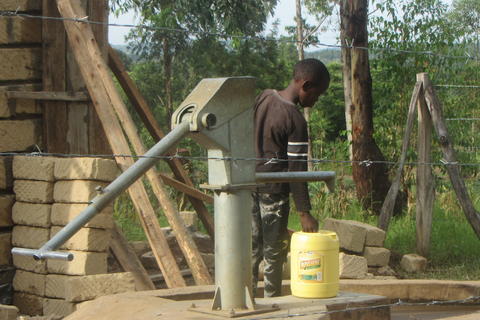 Boy fills jerrycan at Kawegi site.